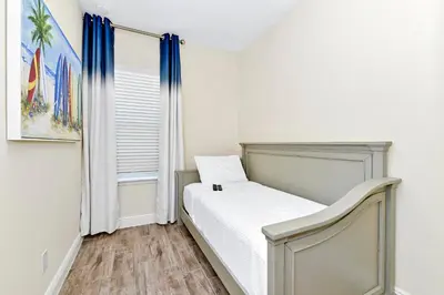 a white bedroom with a bed and a window at Relaxing Villa Near Disney With Margaritaville Resort & Island H20 Waterpark Access - 2992Cs in Orlando