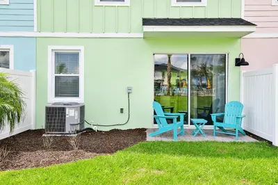 a patio with two blue chairs and a grill at Cozy Villa Near Disney With Margaritaville Resort And Island H20 Waterpark Access - 2907Cl in Orlando