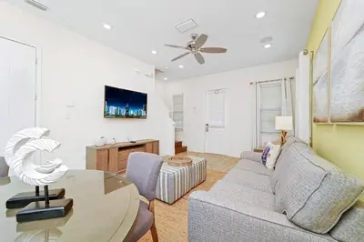 a living room with a couch and a table at Tequila Sunrise Cottage With Private Hot Tub Near Disney With Margaritaville Resort & Island H2O Access - 8008Dr in Orlando