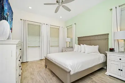 a white bedroom with a bed and a ceiling fan at Tequila Sunrise Cottage With Private Hot Tub Near Disney With Margaritaville Resort & Island H2O Access - 8008Dr in Orlando