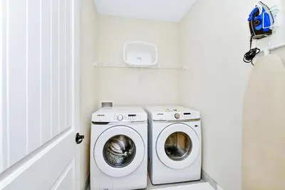 a laundry room with a washer and a washing machine at Tropical Villa Near Disney With Margaritaville Resort & Island H20 Waterpark Access - 3005Cs in Orlando