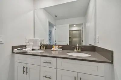 a bathroom with a sink and a large mirror at Storey Lake - Piscina privativa Cama King 4BD/3BA in Kissimmee