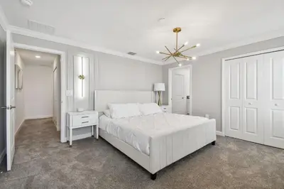 a white bedroom with a white bed and a white door at Storey Lake - Piscina privativa Cama King 4BD/3BA in Kissimmee