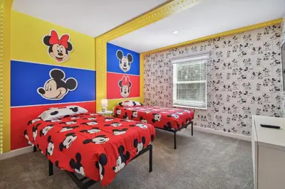 two beds in a room with cartoon characters on the wall at Storey Lake - Piscina privativa Cama King 4BD/3BA in Kissimmee