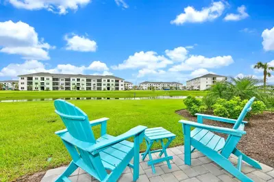 two blue chairs sitting on a patio in front of a building at Bright Blue Villa Near Disney With Margaritaville Resort & Island H20 Waterpark Access - 3085Cs in Orlando