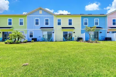 a large apartment building with a green yard at Blissful Villa Near Disney With Margaritaville Resort & Island H20 Waterpark Access - 3109Cs in Orlando