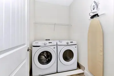 a washer and dryer in a white laundry room at Pleasant Villa Near Disney With Margaritaville Resort & Island H20 Access - 2916Or in Orlando