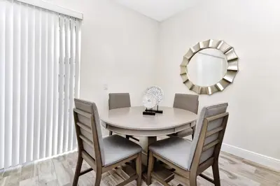 a dining room with a round table and chairs and a mirror at Pleasant Villa Near Disney With Margaritaville Resort & Island H20 Access - 2916Or in Orlando