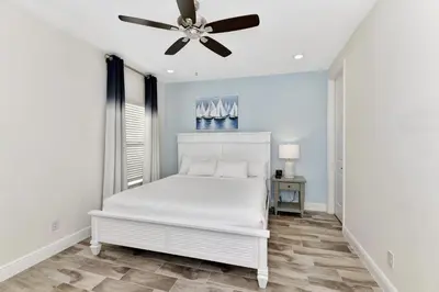 a bedroom with a white bed and a ceiling fan at Pleasant Villa Near Disney With Margaritaville Resort & Island H20 Access - 2916Or in Orlando