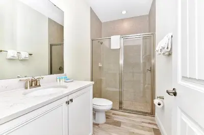 a white bathroom with a shower and a toilet at Spacious Villa Near Disney With Margaritaville Resort & Island H20 Waterpark Access - 2938Cl in Orlando