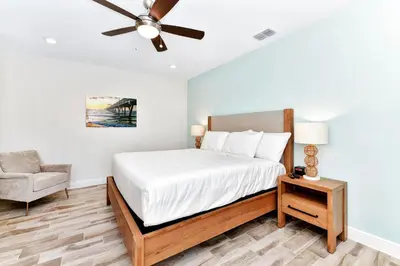 a bedroom with a bed with a ceiling fan and a chair at Spacious Villa Near Disney With Margaritaville Resort & Island H20 Waterpark Access - 2938Cl in Orlando