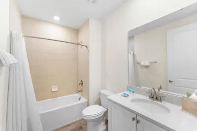 a bathroom with a sink and a toilet and a mirror at Relaxing Paradise Villa Near Disney With Margaritaville Resort & Island H20 Waterpark Access - 2951Cl in Orlando