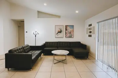a living room with a black couch and a table at Vista para o lago Casa c/piscina in Kissimmee