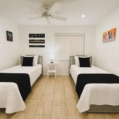 a bedroom with two beds and a ceiling fan at Vista para o lago Casa c/piscina in Kissimmee