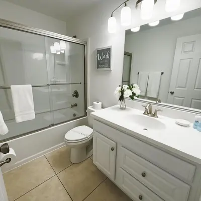 a bathroom with a sink and a toilet and a mirror at Vista para o lago Casa c/piscina in Kissimmee