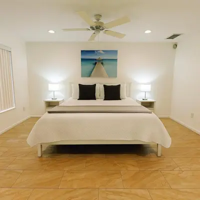 a bedroom with a bed with a ceiling fan at Vista para o lago Casa c/piscina in Kissimmee