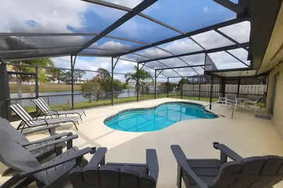 a swimming pool with lounge chairs and a swimming poolvisorangering at Vista para o lago Casa c/piscina in Kissimmee