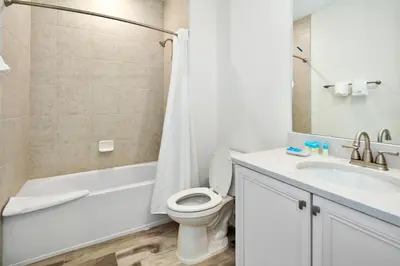 a white bathroom with a toilet and a sink at Dreamy Blue Villa Near Disney With Margaritaville Resort & Island H20 Waterpark Access - 2961Cs in Orlando