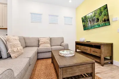 a living room with a couch and a coffee table at White Sand Cottage With Private Pool Near Disney With Margaritaville Resort & Island H2O Access - 8023Kd in Orlando