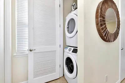 a laundry room with a washer and dryer next to a door at Casa Blanca Cottage With Hot Tub Near Disney With Margaritaville Resort & Island H2O Access - 8032Su in Orlando