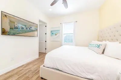 a white bedroom with a large bed and a window at Sunset Cottage Near Disney With Margaritaville Resort & Island H2O Access - 8065Ls in Orlando