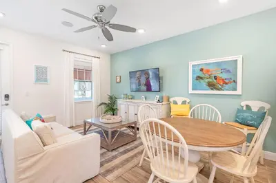 a living room with a table and a couch at No Shoes Retreat! Cottage With Hot Tub Near Disney With Margaritaville Resort & Island H2O Access - 8085Dr in Orlando