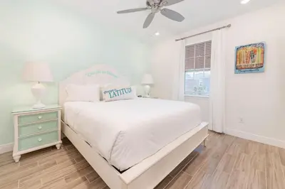 a white bedroom with a bed and a ceiling fan at No Shoes Retreat! Cottage With Hot Tub Near Disney With Margaritaville Resort & Island H2O Access - 8085Dr in Orlando