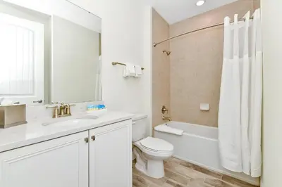 a white bathroom with a toilet and a sink at Sunny Villa Near Disney With Margaritaville Resort & Island H20 Access - 8170Cp in Orlando