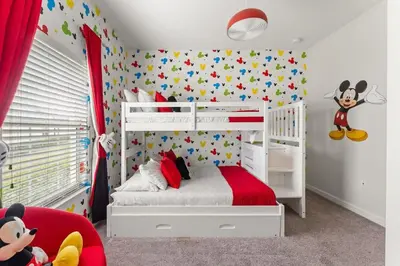 a bedroom with a bed with mickey mouse wallpaper at 5 BR Disney themed bedrooms SL 4825 in Kissimmee