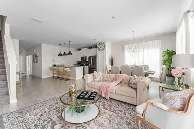 a living room with two couches and a kitchen at 5 BR Disney themed bedrooms SL 4825 in Kissimmee