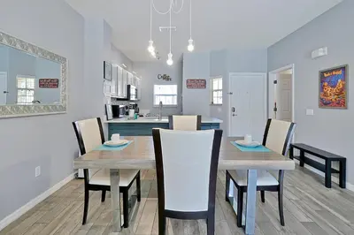 a dining room and kitchen with a table and chairs at Encantada Resort: Pool, Gym, Clubhouse, Near Disney in Kissimmee