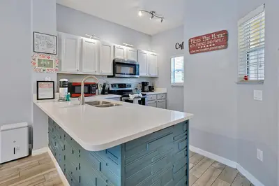 a kitchen with blue cabinets and a white counter top at Encantada Resort: Pool, Gym, Clubhouse, Near Disney in Kissimmee