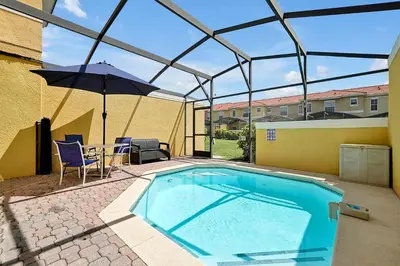 a swimming pool with an umbrella and a table and chairs at Encantada Resort: Pool, Gym, Clubhouse, Near Disney in Kissimmee