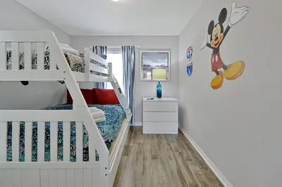 a white bedroom with a bunk bed with a ladder at Encantada Resort: Pool, Gym, Clubhouse, Near Disney in Kissimmee