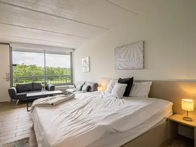 a large white bed in a room with a window at Fun filled 1BR Close to Disney Parks With Lake view in Vineland