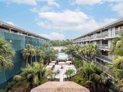 an aerial view of the courtyard of a resort with palm trees at Relax & Enjoy 1BR Home Near Disney Parks With Lake view in Kissimmee