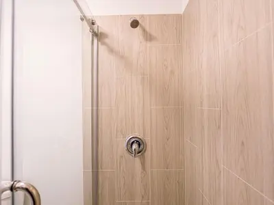 a shower with a wooden door in a bathroom at Delightful 1BR Condo Next to Disney With Lake view in Vineland