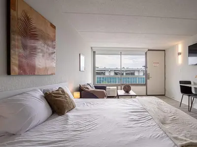a bedroom with a large bed and a living room at Lovely 1BR Suite Minutes to Disney With Lake view in Vineland