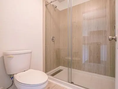 a bathroom with a toilet and a glass shower at Lovely 1BR Suite Minutes to Disney With Lake view in Vineland