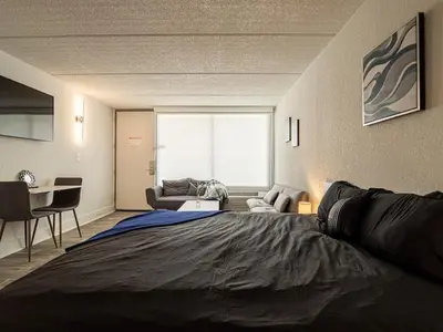 a bedroom with a large bed and a living room at Elegant 1BR Haven in Orlando & 5 minutes to Disney in Vineland