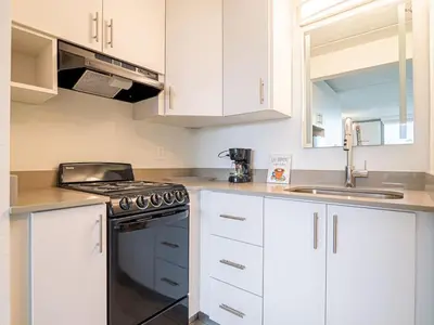 a white kitchen with a stove and a sink at Welcoming 1BR Gateway Orlando 5 minutes to Disney in Vineland