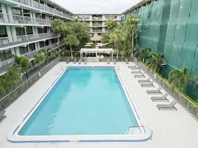 an empty swimming pool with lounge chairs and a building at Comfy 1BR Space in Orlando & 5 minutes to Disney in Vineland