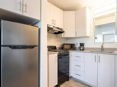 a kitchen with white cabinets and a stainless steel refrigerator at Orlando Prime Location 1BR Home 5 minutes to Disney in Kissimmee