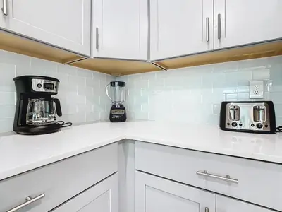 a kitchen with white cabinets and a blender on the counter at Once Upon a Villa in Kissimmee