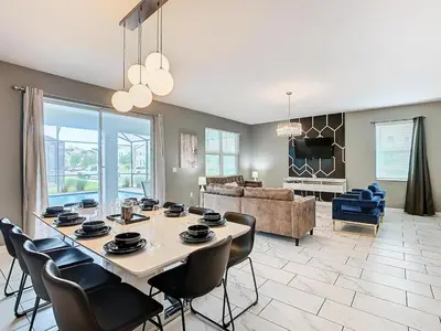 a dining room with a table and chairs in a living room at Once Upon a Villa in Kissimmee