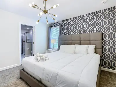 a bedroom with a large white bed and a wall at Once Upon a Villa in Kissimmee