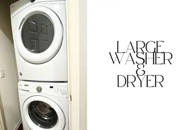 a washing machine in a bathroom next to a door at Spacious 4-Bedroom Family Retreat Near Disneyland! in Kissimmee