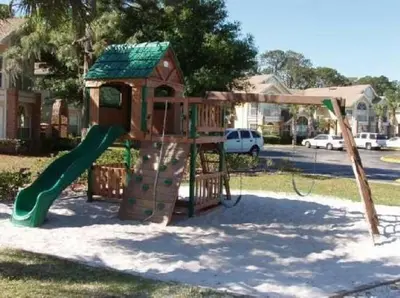 a small playground with a slide and a house at 2492 Your home away from Home in Kissimmee