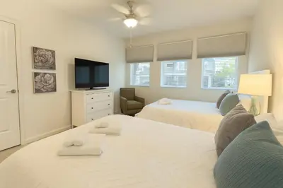 a living room with two beds and a tv at 2612 LunaPi Villa 7Bd Private Pool and Family Room in Kissimmee