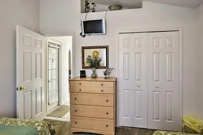 a bedroom with a dresser and a tv on a wall at 4 Bedroom Villa - Indian Creek in Kissimmee